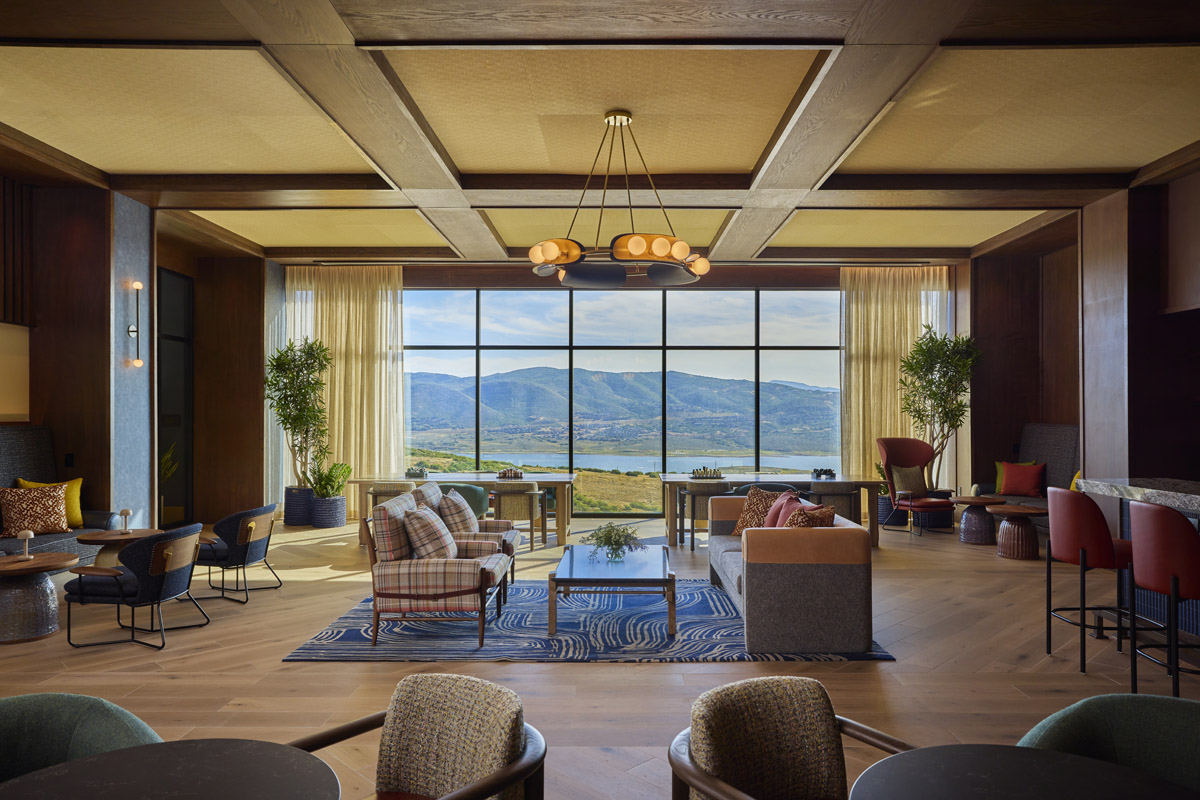 A spacious lobby with a large window, seating area, coffee table, and plants.